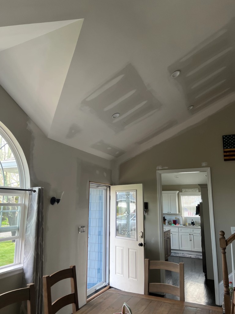 Vaulted ceiling and walls with joint compound on seams and patches near window and door trim