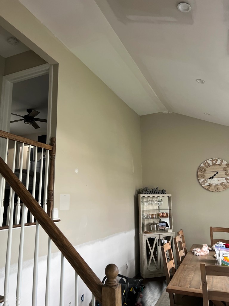Sloped ceiling with compound stripes around recessed lights and along the ceiling-wall joint